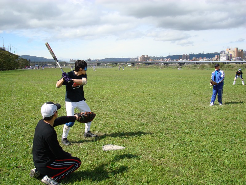 Coach Lin helps the players practice batting