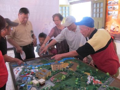 People from Ruan Qiao   were talking in front of the   model of their area.